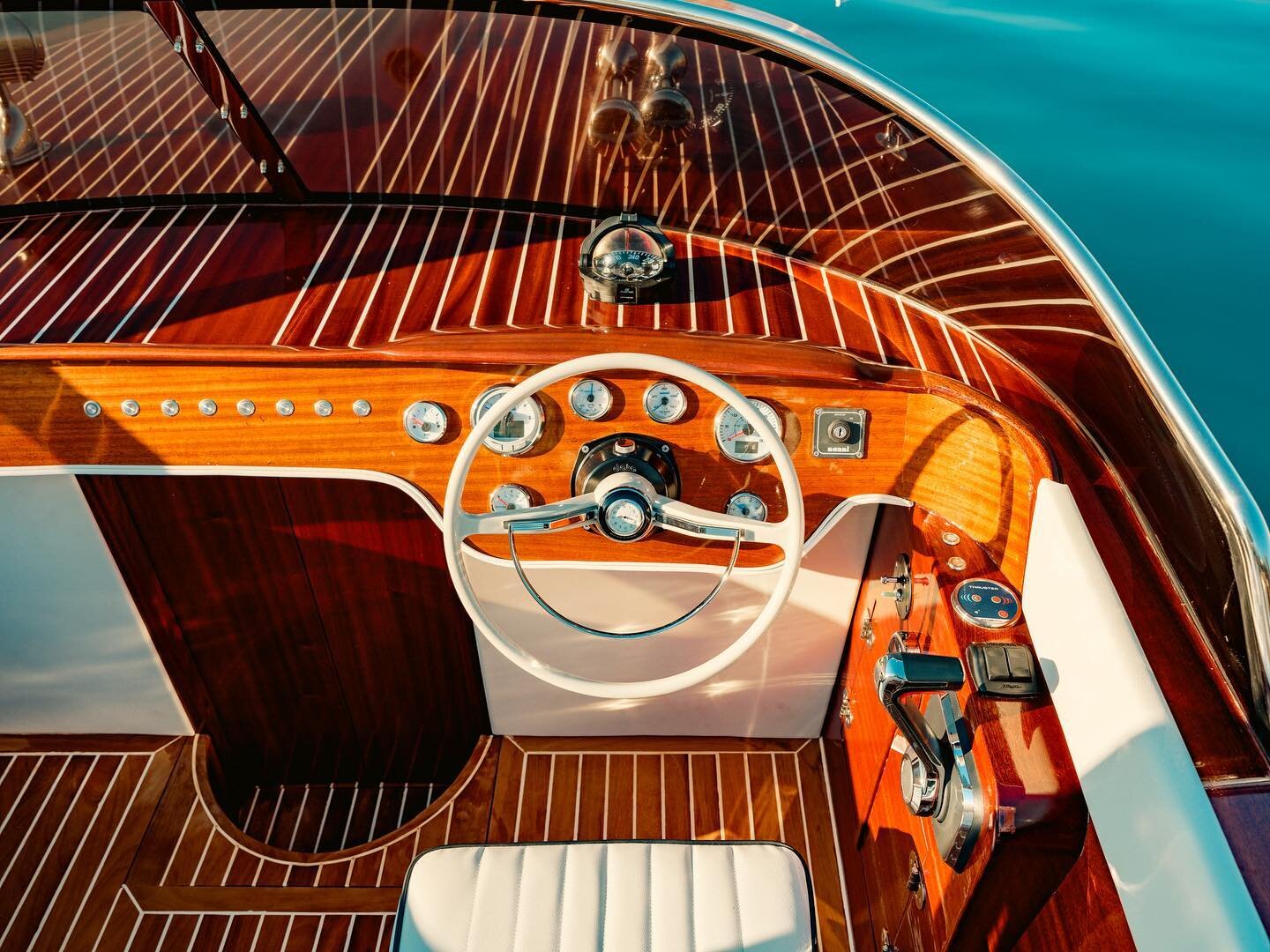 Teak decking and classic helm of the Aurora 27